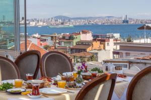 a dining room table with chairs and umbrellas at Darussaade Istanbul Hotel in Istanbul