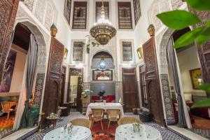 a room with a table and chairs and a chandelier at Riad Dar Cordoba in Fès