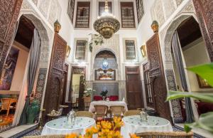 a room with two tables and a chandelier at Riad Dar Cordoba in Fès