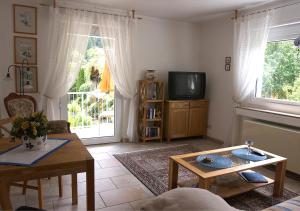 ein Wohnzimmer mit einem TV und einem Tisch in der Unterkunft Ferienwohnung-Mosel in Traben-Trarbach