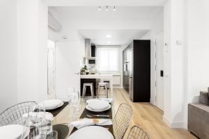 マドリードにあるJose Abascal Apartment by Flatsweethomeの白い壁のダイニングルーム(テーブル、椅子付)