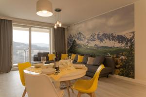 uma sala de estar com uma mesa e um sofá em Apartament Na Urlop - Wisła Kamienna - Apartamenty z widokiem na panoramę Wisły em Wisla