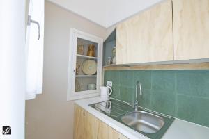 a kitchen with a sink and wooden cabinets at Kees Apulian Stay in Monopoli +56 photos