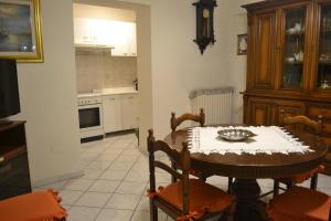 una cucina con tavolo e sedie e una cucina con piano cottura di Appartamento Tuscany a Cenaia