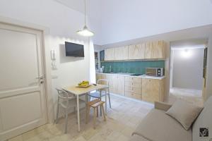 a living room with a table and a kitchen at Kees Apulian Stay in Monopoli