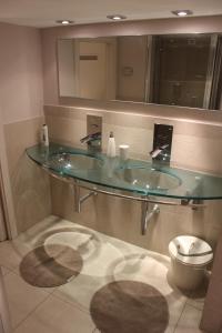 a bathroom with a glass sink and a toilet at Suite Manzoni in Rome