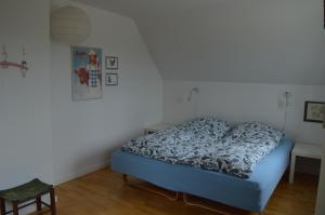 Schlafzimmer mit einem Bett mit blauer Decke in der Unterkunft Bed and Birds B&B in Skibby