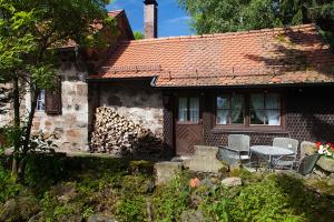 uma casa com uma mesa e cadeiras em frente em Rhönhäuschen UG (haftungsbeschränkt) em Bischofsheim an der Rhön