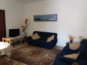 un soggiorno con 2 divani blu e una TV di Cami Vell a Vilafamés