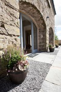 un edificio de piedra con una puerta y algunas plantas en Blairmore Farm en Crieff