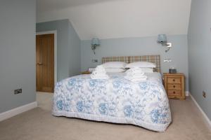 um quarto com uma cama com uma colcha azul e branca em Blairmore Farm em Crieff