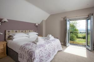ein Schlafzimmer mit einem großen Bett und einem großen Fenster in der Unterkunft Blairmore Farm in Crieff