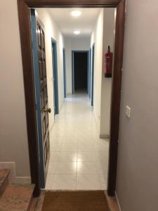 a hallway with blue doors and a white tile floor at A Senda in Caldas de Reis