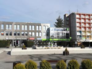 a city square with a fountain in front of buildings at Penzion Luxury in Rožňava