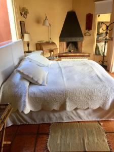 1 dormitorio con cama blanca y chimenea en Bungalow in Our Garden en Montevideo