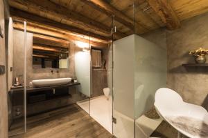 uma casa de banho com uma cabina de duche em vidro e um lavatório. em Relais Bondaz em Aosta