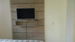 un televisor sentado en una pared con una pared de ladrillo en Flat Studio Tambaú Perto de Tudo, en João Pessoa