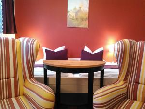 ワイマールにあるLandhotel Possendorfのテーブルと椅子2脚が備わる客室です。