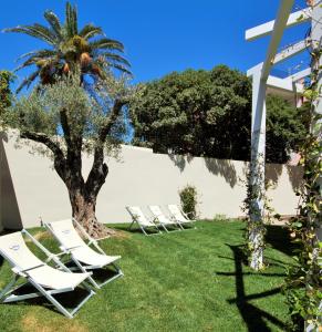 a group of lounge chairs under a palm tree at Hotel Nautilus in Cagliari