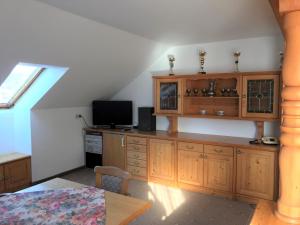 a kitchen with wooden cabinets and a television and a table at Bruckerhof in Puchberg am Schneeberg