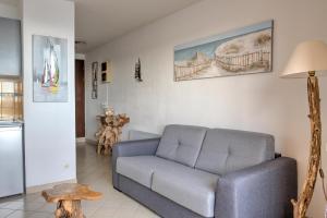 een woonkamer met een bank en een tafel bij Appartement Le Flamant Rose in Port-la-Nouvelle