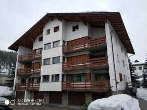 un edificio con balcones de madera en la nieve en Studio Room, en Celerina