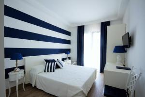 a bedroom with a blue and white striped wall at Hotel Nautilus in Cagliari