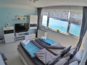 a living room with a couch and a large window at Studio apartment More in Rabac