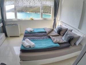 a bed in a room with two windows at Studio apartment More in Rabac