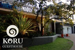 a house with a sign that reads kron guest house at Koru Guesthouse in Pretoria