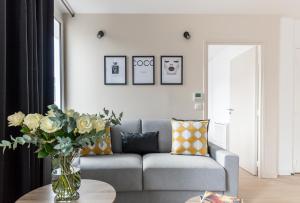 a living room with a couch and a vase of flowers on a table at Résidence Palais Étoile in Paris