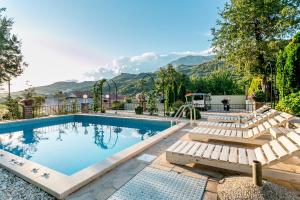 a swimming pool with lounge chairs and a swimming poolvisorvisor at Villa Besha in Herceg-Novi