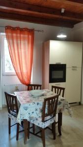 a dining room table with chairs and an orange curtain at la civetta sul como' in La Spezia
