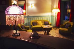 lampa siedząca na stole w salonie w obiekcie The Old Hotel Ravel Centre w mieście Clermont-Ferrand