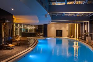 a large swimming pool in a hotel with blue lighting at Hotel Las Americas Golden Tower Panamá in Panama City