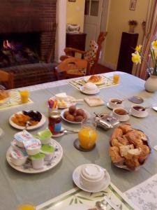 una mesa llena de alimentos para el desayuno y zumo de naranja en Ferme de Dauval, en Mandeville-en-Bessin