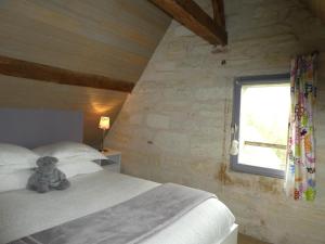 a teddy bear sitting on a bed in a bedroom at Le Balcon De Leonard in Amboise