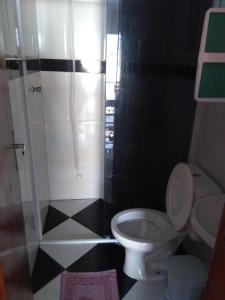 y baño pequeño con aseo y ducha. en Pousada Pingo de Ouro, en Florianópolis