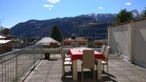 een tafel en stoelen op een balkon met uitzicht op de bergen bij Nuovo appartamento a Clusone in Clusone