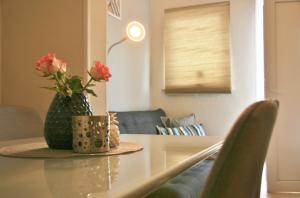 un vaso con fiori su un tavolo in soggiorno di Apartma Tul a Izola