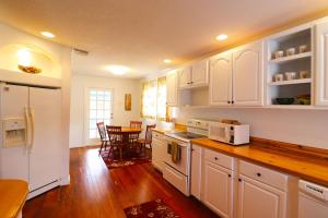 a kitchen with white cabinets and a wooden floor at Big River Marina & Lodge in Astor