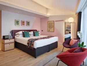 a bedroom with a large bed and two chairs at Marrable's Farringdon Hotel in London