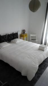 1 cama blanca grande en un dormitorio blanco en Vasco Santana Guesthouse, en Odivelas