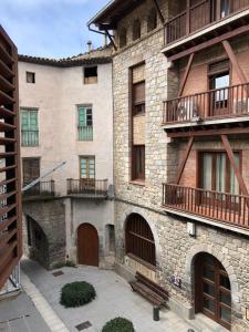オルラニャにあるCa la Conxitaのバルコニーと中庭付きの大きな石造りの建物