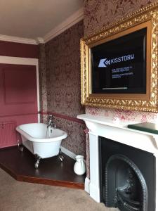 a bathroom with a fireplace and a television at The Lady Elizabeth Hotel in Sudbury