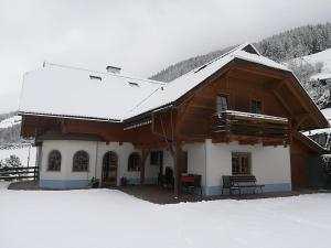 une maison avec de la neige sur le toit dans l'établissement Gästehaus Laßnig, à Ebene Reichenau