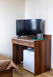 a flat screen tv sitting on top of a wooden entertainment center at M&A GUEST ROOMS in Łomża