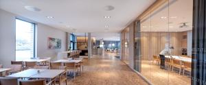 a man standing in a restaurant with tables and chairs at Ydalir Hotel in Stavanger