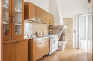 a kitchen with wooden cabinets and a white stove at Casetta Canale delle Donne in Marina di Mancaversa