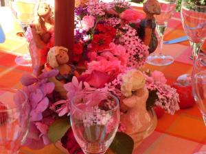 een tafel met bloemen, teddyberen en wijnglazen bij Auberge Saint Aubin in Saint-Aubin-le-Monial